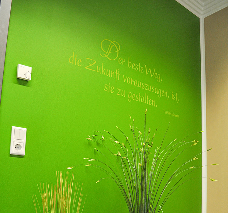 grüne Wand mit dekorativen Spruch