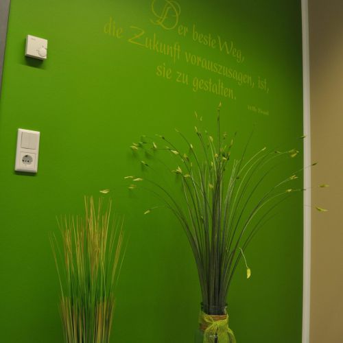 Grüne Wand mit dekorativen Spruch und Dekopflanzen