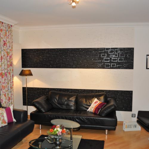 Wohnzimmer mit schwarzen Möbeln und Wanddekoration